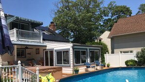 A backyard with a swimming pool, a covered patio area, and a fenced deck. - Key West in Cape May: Hot tub open year round! Dog friendly! (Villas)