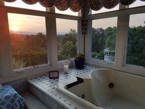 A bathroom with a bathtub, a potted plant, and a view of the outdoors. - Monet HoneymoonSuite in villa.Elegant Lrg 2rm w/balcony, jacuzzi n phenom.view. (Purcellville)