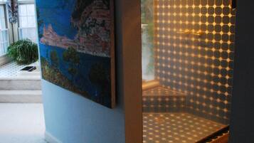 A room with a large painting on the wall, a patterned glass door, and a carpeted floor.