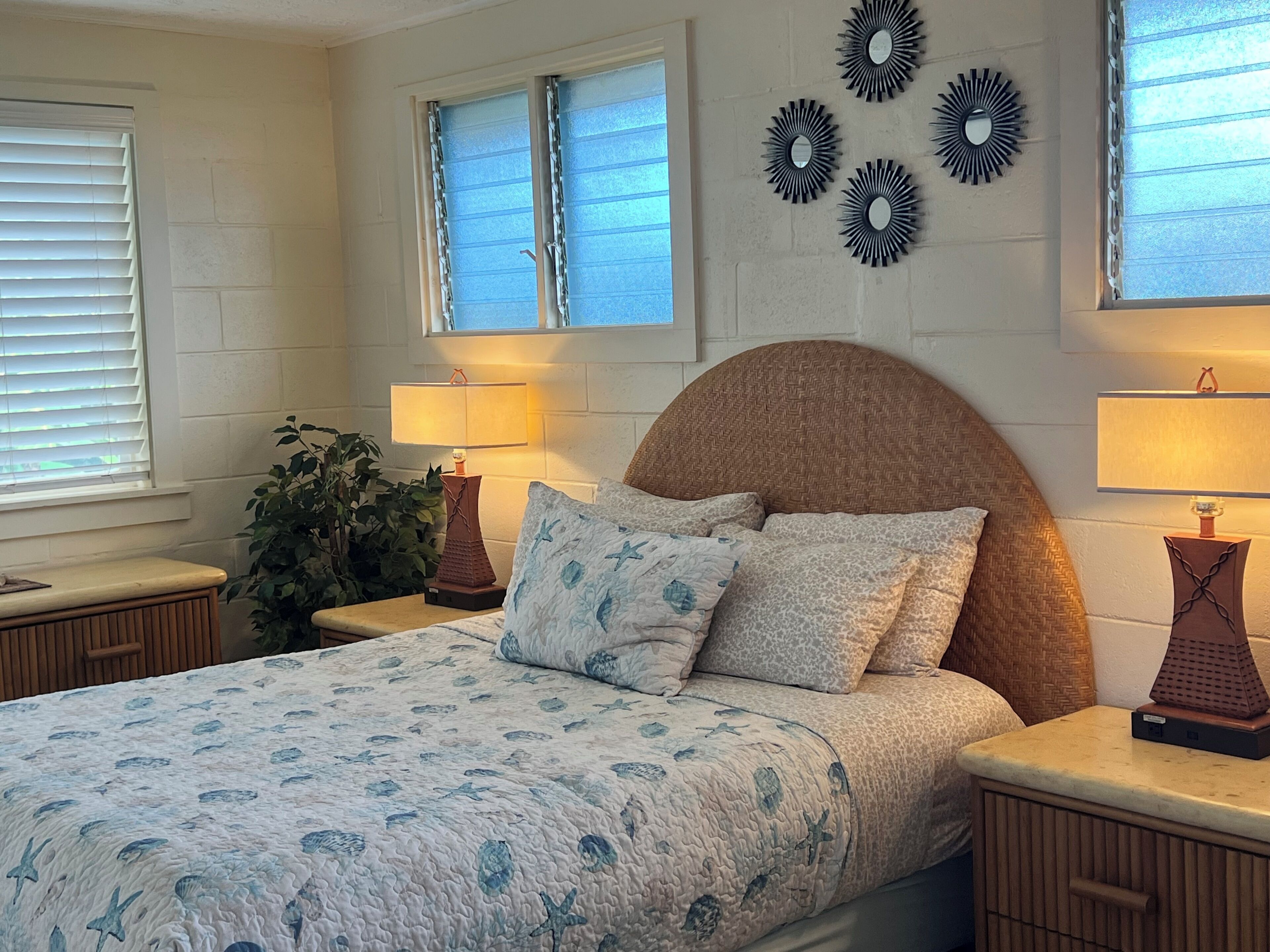 Camera da letto con un letto, due comodini, una finestra con tende e decorazioni alle pareti.