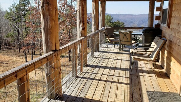 A wooden deck with a railing, outdoor furniture, and a view of trees and mountains. - Dogwood Cabin, Deer Lodge Cabin Rentals is a Secluded Ozark Mountain Log Cabin.  (Jasper)