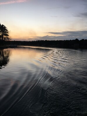 A calm river with a boat, trees, and a distant shoreline. - Lakefront home in a Gated Community, 10 miles from Pinehurst Village (Seven Lakes)