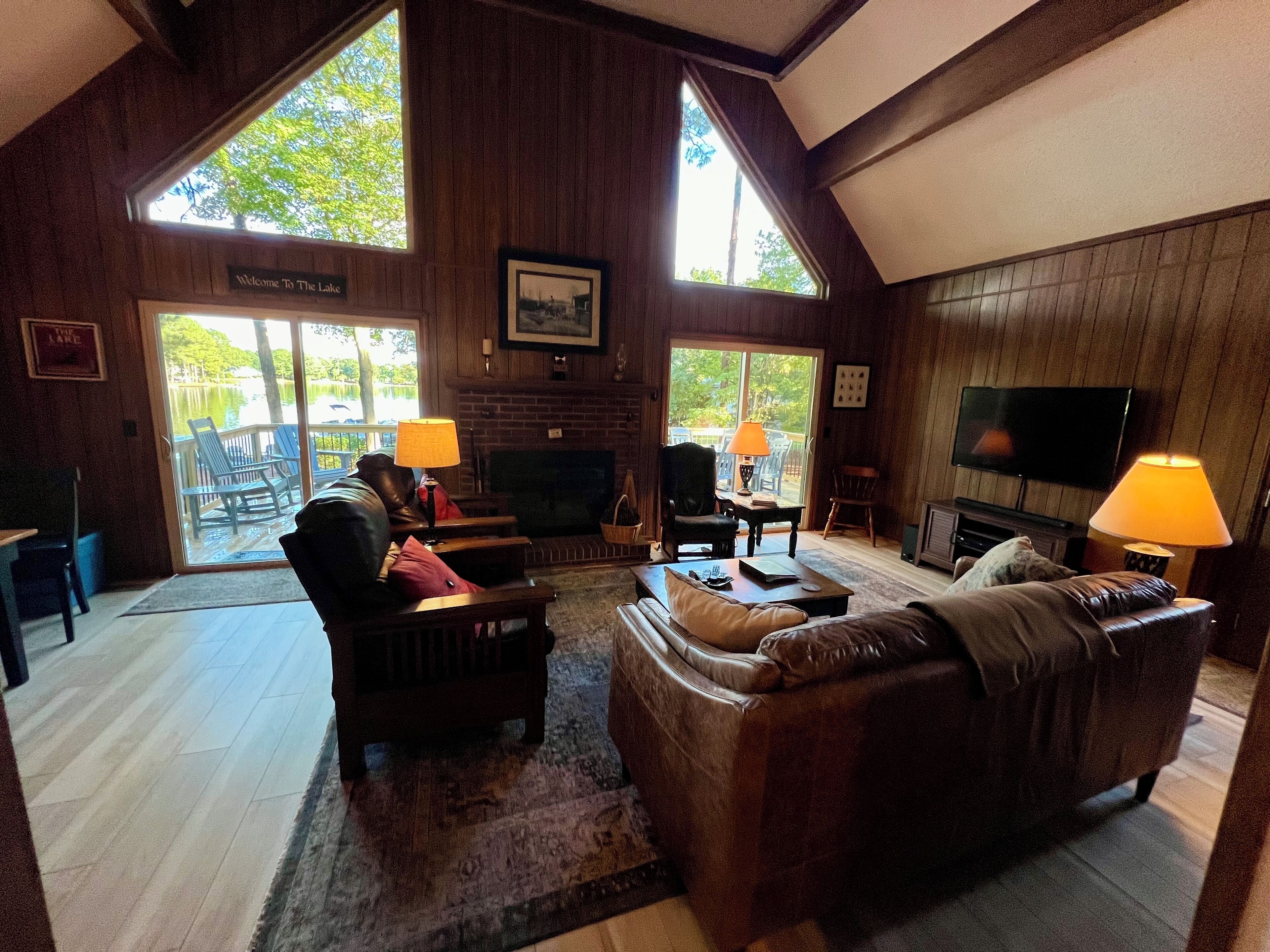 A cozy living room with a fireplace, leather sofas, and a TV.
