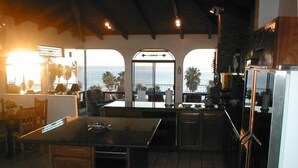 Una cocina con una isla grande, armarios de madera y vistas al océano.