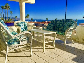 Relax on the ocean-view terrace with a sofa and armchairs, surrounded by patterned cushions.