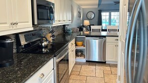A kitchen with white cabinets, a microwave, a stove, a dishwasher, and a refrigerator. - Luxury 4BR Townhouse, 2 Primary Bedrooms, east of route 1, POOL,  close to beach (Rehoboth Beach)