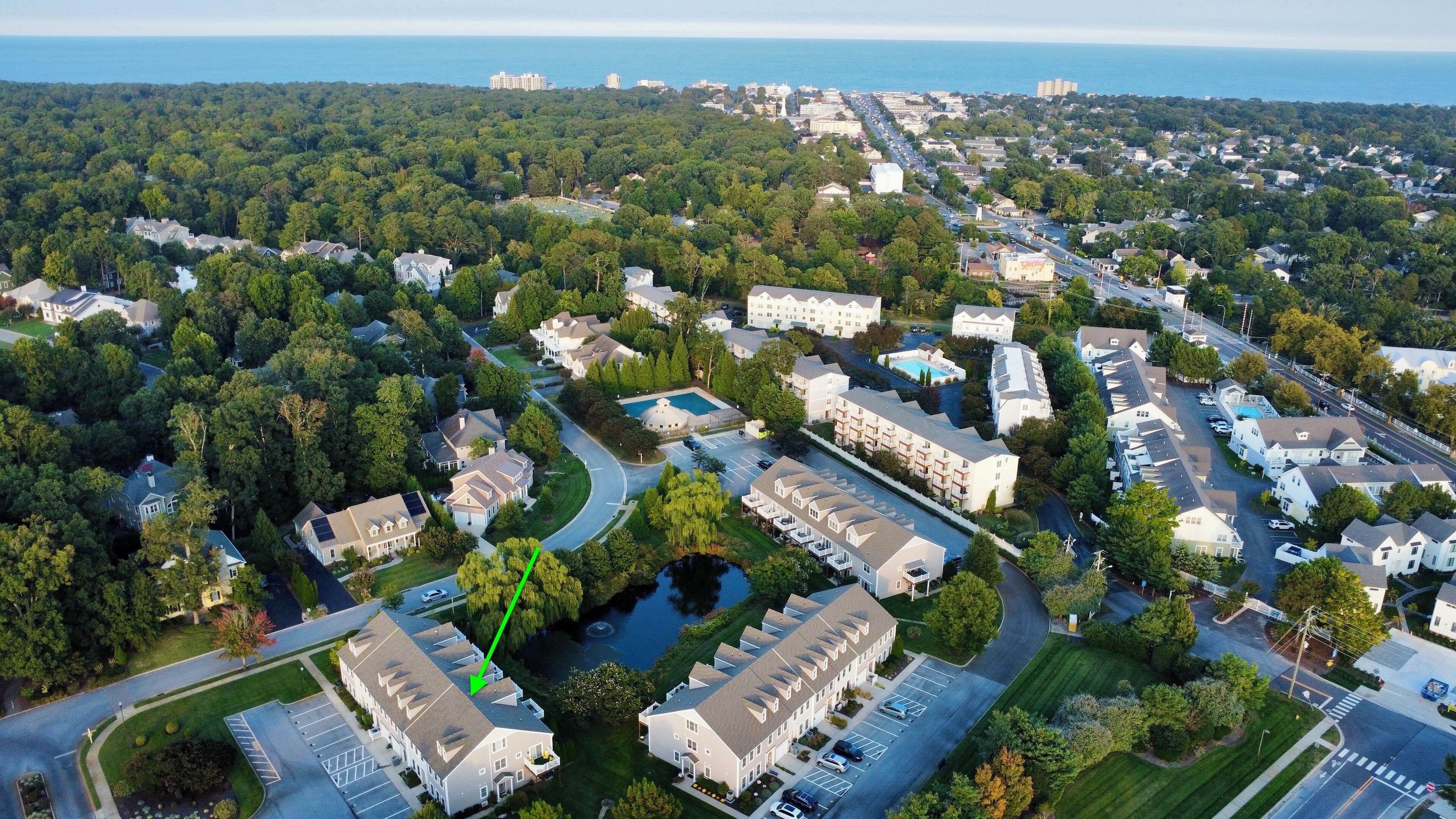 Vista aérea de una zona residencial con un gran complejo de edificios, calles y una masa de agua.
