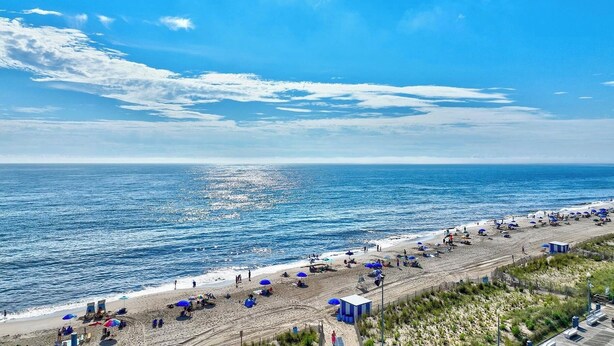 A beach with umbrellas, a lifeguard tower, and a clear view of the ocean. - Luxury 4BR Townhouse, 2 Primary Bedrooms, east of route 1, POOL,  close to beach (Rehoboth Beach)