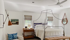 A bedroom with a four-poster bed, a bedside table, a chair, a bench, a small stool, and a window with curtains. - Antique Home with Heated Salt Water Pool (Harwich)
