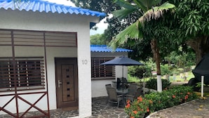 Un edificio con un patio de piedra, zona de barbacoa y el número 10 en la pared.
