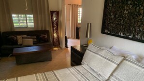 Un dormitorio con cama, sofá, mesita de noche y lámpara.