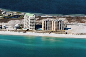 Een kusthotel met meerdere hoge gebouwen, een strand en een jachthaven.