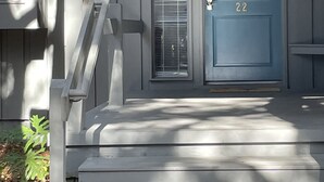 A gray house with a blue door marked with the number 22, a small porch with a bench, and a mailbox with a flag. - Villa; 5 minute walk to Palmetto Dunes Beach with a Great Golf Course View!! (Hilton Head Island)