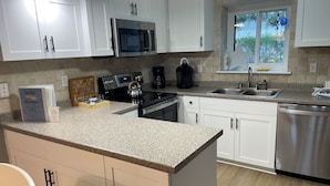 A modern kitchen with white cabinets, stainless steel appliances, granite countertops, and a built-in dishwasher. - Villa; 5 minute walk to Palmetto Dunes Beach with a Great Golf Course View!! (Hilton Head Island)
