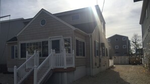 Ein zweistöckiges Haus mit Veranda, Garage und Kiesweg.