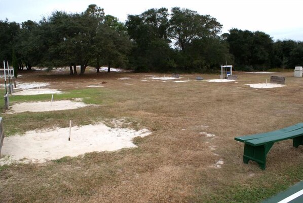 A park with a green bench, sandpits, and trees. - Inquiries are Beginning for Spring and Summer. Hear the Waves from the Balcony. (Gulf Shores)