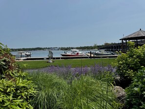 A marina with boats docked, a gazebo, and lush greenery. - Carolyn's Bass River Condo (Yarmouth)