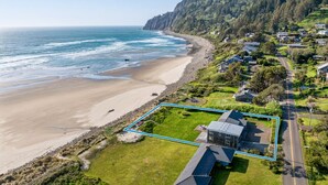 A coastal property with a beach view, a road leading to the houses, and a forested hillside. - Manzanita Oregon beach house (Nehalem)