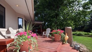 A wooden deck with potted plants and outdoor furniture.