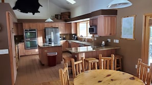 Enjoy cooking in this well-equipped kitchen with a central island, sink, and dining area.
