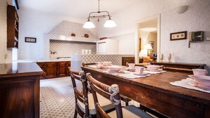 A traditional kitchen with a wooden table set for dining, a patterned backsplash, and a hanging light fixture. - Classy apartment with lake-view terrace and parking (Cernobbio)