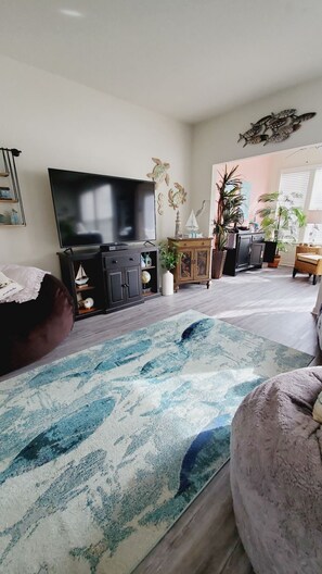 Relax in this inviting space with a flat-screen TV, comfortable seating, and a beautiful potted plant.