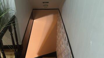 Una escala amb barana de fusta i un mur amb disseny.