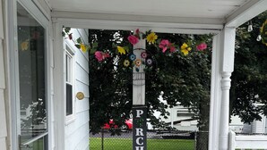 A porch with a welcome mat, a decorative flower arrangement, and a sign with the word "PARCH". - ATV and Snowmobile right from the house !!!! (Berlin)