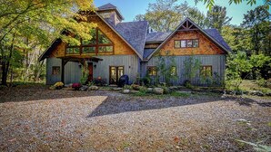 Une cabane rustique avec des fondations en pierre, un revêtement extérieur en bois et une allée gravillonnée.