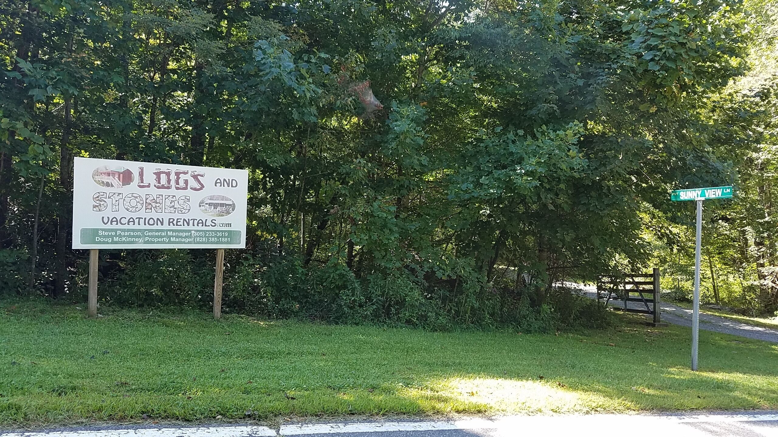 A signboard for a vacation rental property with contact information for a general manager and a property manager.