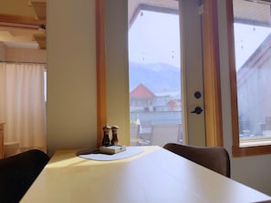 Enjoy breathtaking mountain views from the large window in this serene room, featuring a simple design and a comfortable seating area.