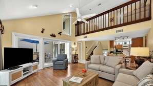 A spacious living room with a flat-screen TV, a wooden coffee table, and a staircase leading to an upper level. - SeaPines, Updated, Walk to the Beach Club, Pet friendly, Two free bikes (Hilton Head Island)