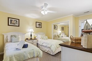 A hotel room with two beds, a ceiling fan, bedside lamps, a nightstand, a mirror, and a small table with a basket and a scale. - SeaPines, Updated, Walk to the Beach Club, Pet friendly, Two free bikes (Hilton Head Island)