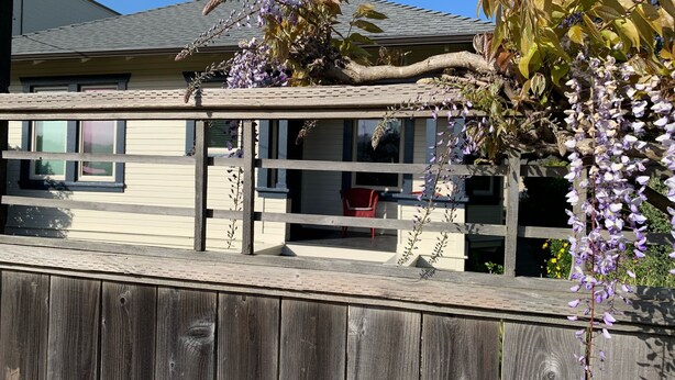 A wooden fence with a view of a house and a garden. - Lavender House Cottages, Classic Elegance in a Country Cottage (Point Reyes Station)