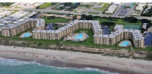 Ein Küstenhotel mit mehreren Gebäuden, jedes mit einem Pool und Blick auf den Strand.