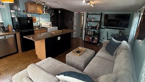 Una sala de estar moderna con un sofá gris, una mesa de centro y un televisor montado en la pared.
