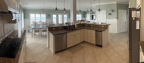 A spacious kitchen with granite countertops, a dishwasher, and a large island.