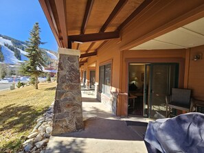 A covered outdoor area with stone pillars, a patio with chairs, and a view of snow-capped mountains. - Premium Gold rated, Ski in+out, 1st floor walkout! VIEWS and UPGRADES! (Frisco)