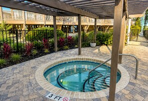 A covered outdoor swimming pool with a 3 FT depth marker, surrounded by a brick patio and a wooden deck. -     Beach Escape! 2-Min Walk to Beach, Dining, Pool, Spa & Elevator (North Myrtle Beach)