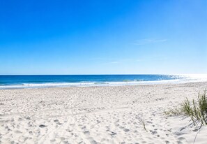 A sandy beach with footprints and sparse vegetation. -     Beach Escape! 2-Min Walk to Beach, Dining, Pool, Spa & Elevator (North Myrtle Beach)