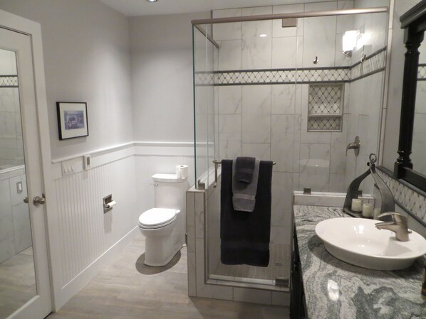 A modern bathroom with a glass-enclosed shower, a white toilet, and a marble sink. - Wine Country 2 bedroom Cottage (with Optional 1 bedroom Guest House) (Sonoma)