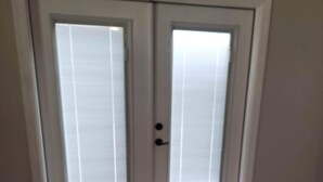 A double door with frosted glass panels and a black handle.