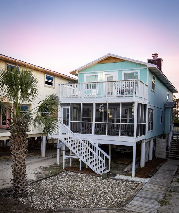 A two-story house with a balcony and a staircase leading to the upper floor.