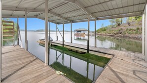 A covered dock with a view of a lake and a small dock in the background. - Log Cabin On Lake Keowee-Big Lake Mountain Views (Six Mile)