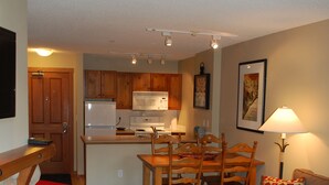 A compact living space with a kitchenette, dining area, and seating. - Convenient and located in the resort village (Sun Peaks)