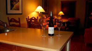 A kitchen counter with a bottle of wine and two wine glasses. - Convenient and located in the resort village (Sun Peaks)