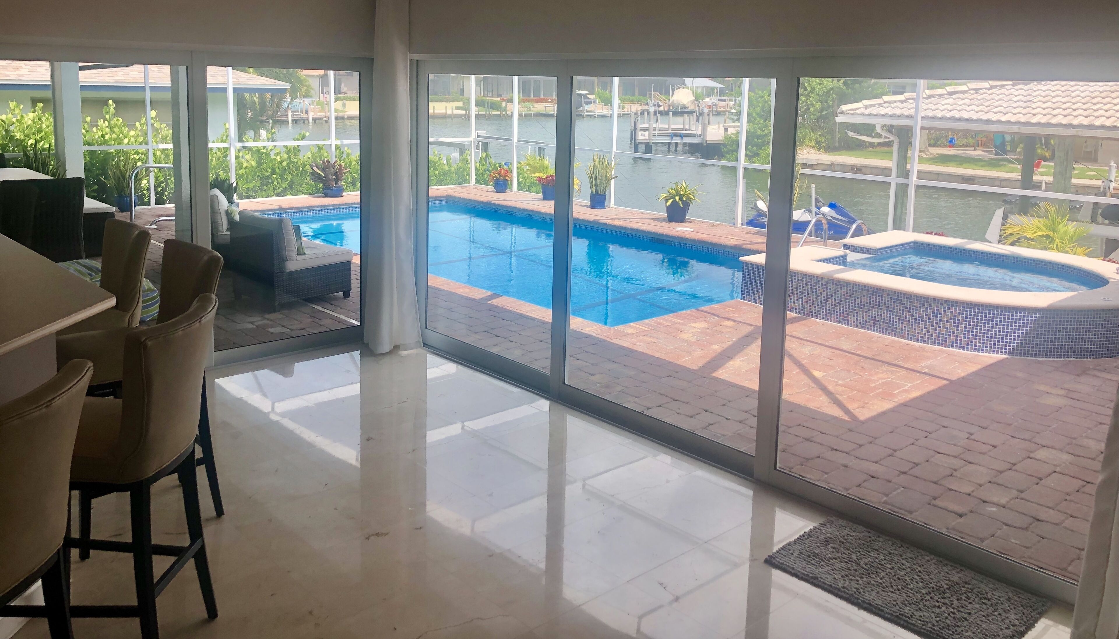 A room with a view of a swimming pool and dock area.