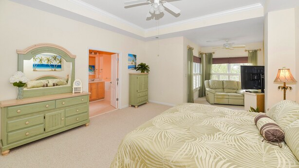 A bedroom with a bed, dresser, and a ceiling fan. - Huge Home Situated on Golf Course; Close to Beach, Outlets, and Restaurants! (Berlin)