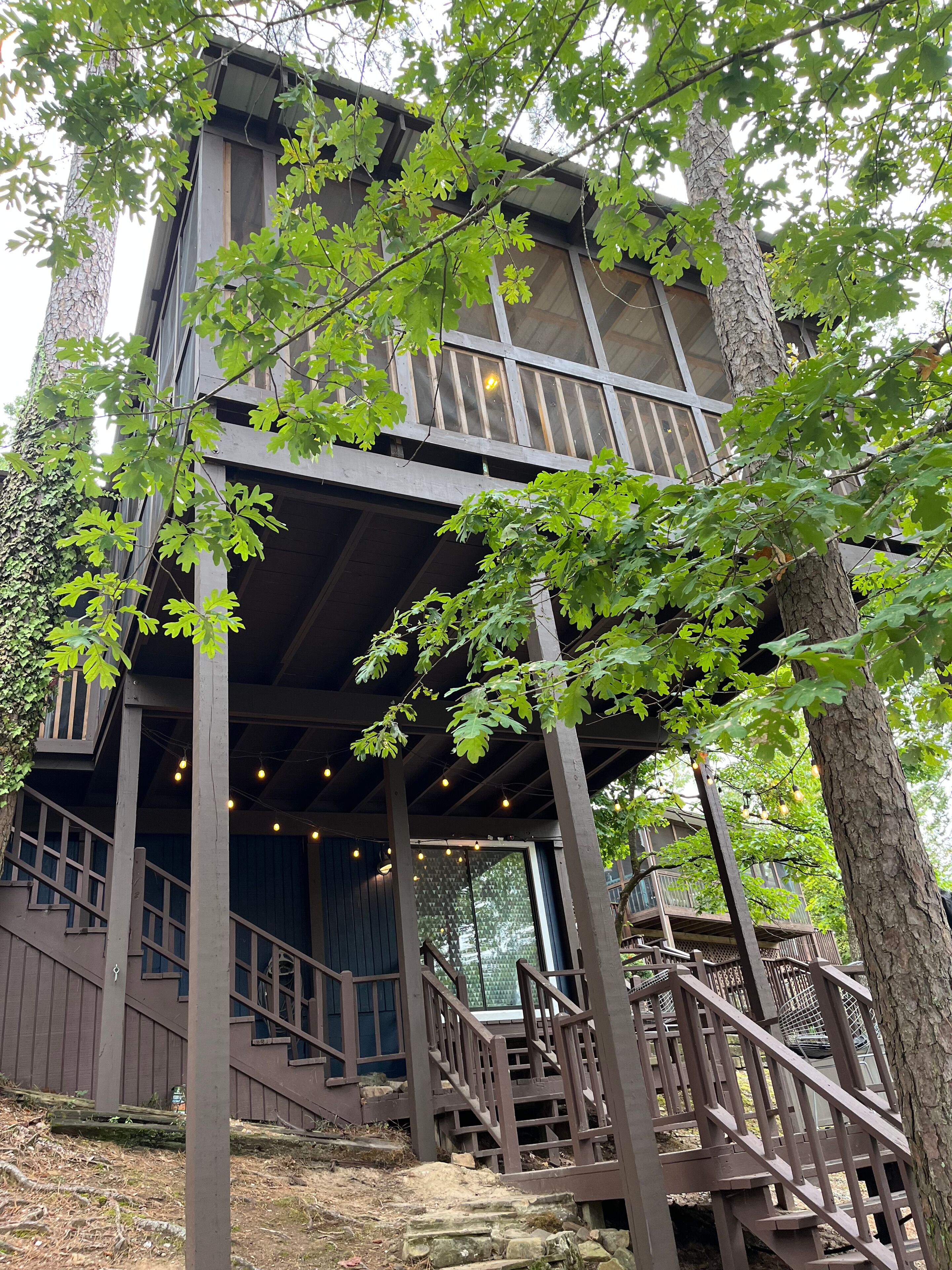 A two-story wooden building with a balcony and outdoor seating area.