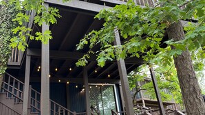 Een tweelaags houten gebouw met balkon en terras.